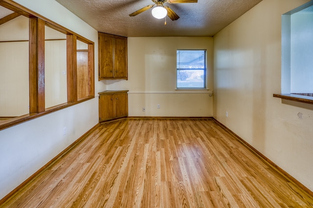 spare room featuring a textured ceiling, light hardwood / wood-style floors, and ceiling fan