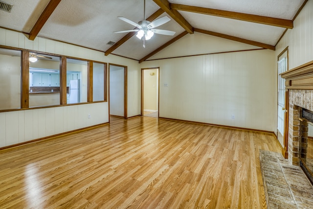 unfurnished living room featuring a textured ceiling, light hardwood / wood-style flooring, ceiling fan, and a brick fireplace