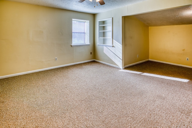 interior space with a textured ceiling, carpet, and ceiling fan