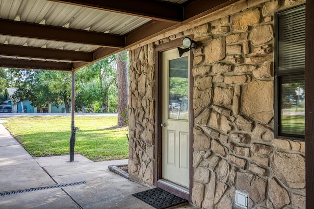 doorway to property with a lawn