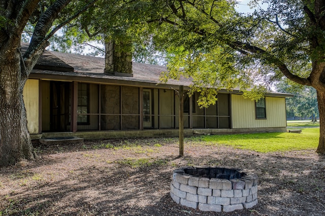 back of house with a fire pit