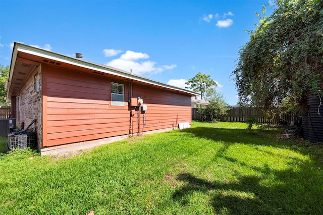 exterior space featuring central AC unit and a yard