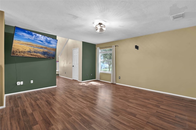 unfurnished room featuring a textured ceiling and dark wood-type flooring