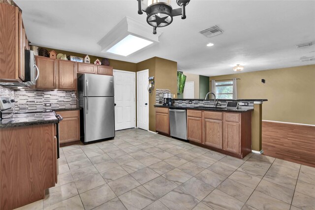 kitchen with tasteful backsplash, sink, kitchen peninsula, light hardwood / wood-style flooring, and stainless steel appliances