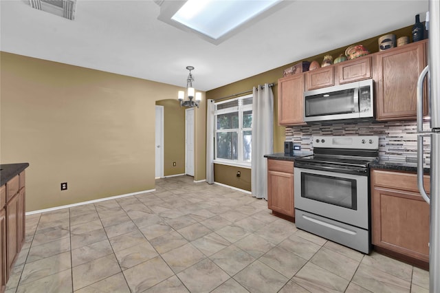 kitchen with a notable chandelier, stainless steel appliances, hanging light fixtures, and tasteful backsplash