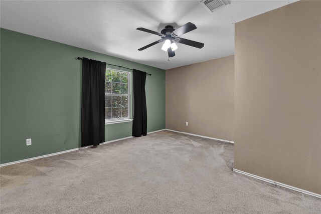 empty room featuring ceiling fan and light colored carpet