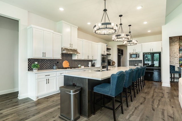 kitchen featuring a center island with sink and white cabinetry