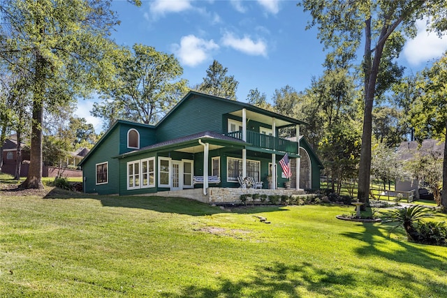 back of house featuring a lawn, a balcony, and a patio