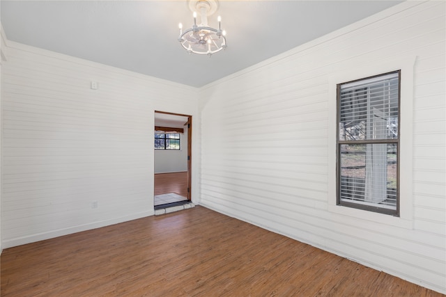 unfurnished room featuring dark hardwood / wood-style floors and a notable chandelier