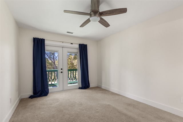 carpeted spare room with ceiling fan and french doors