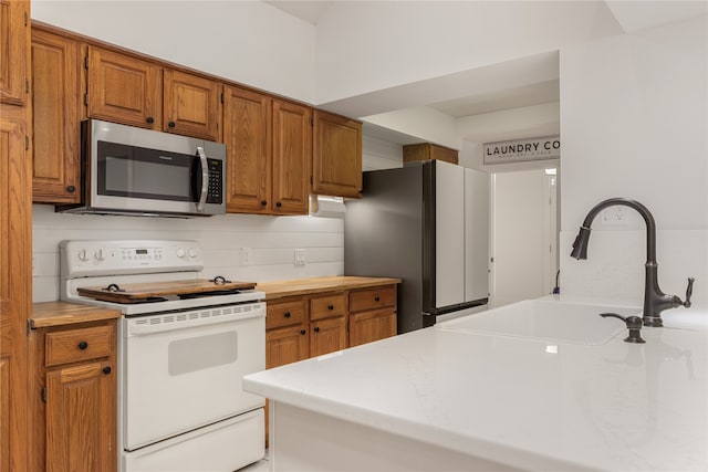 kitchen featuring backsplash, appliances with stainless steel finishes, and sink