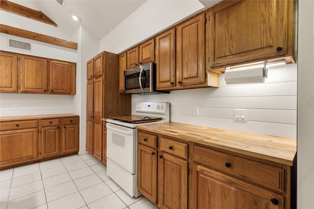 kitchen with light tile patterned flooring, tasteful backsplash, vaulted ceiling with beams, white electric range oven, and wooden counters