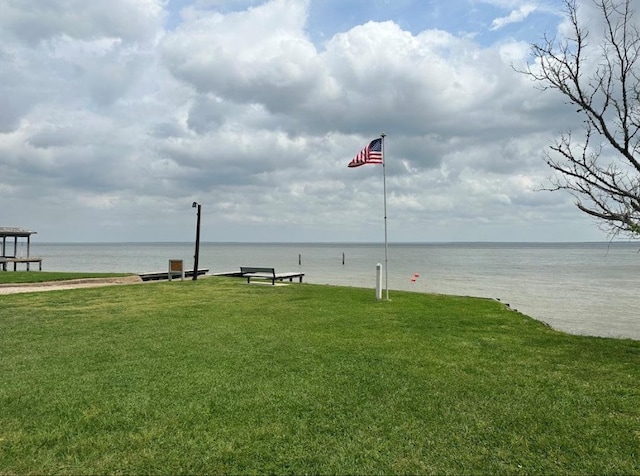 surrounding community featuring a lawn and a water view