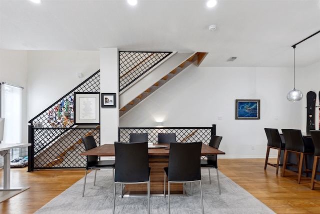 dining area featuring lofted ceiling and light hardwood / wood-style flooring