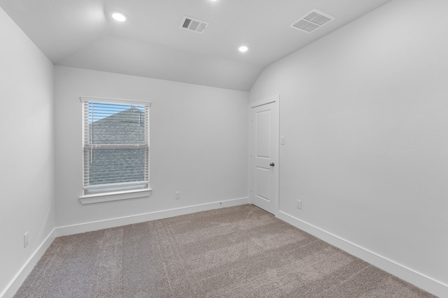 empty room featuring carpet flooring and vaulted ceiling