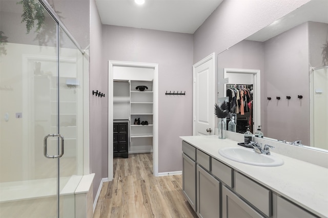 bathroom with vanity, a shower with shower door, and hardwood / wood-style flooring