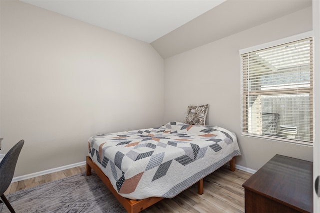 bedroom featuring light hardwood / wood-style floors and lofted ceiling