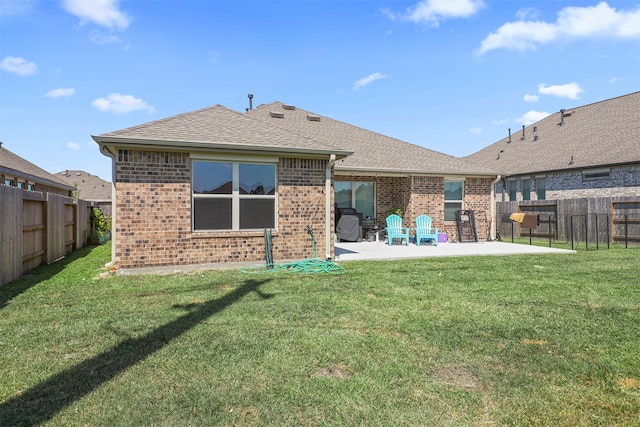 rear view of property with a yard and a patio area