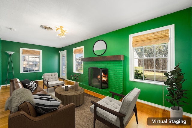 sitting room with a healthy amount of sunlight, light hardwood / wood-style floors, and a fireplace