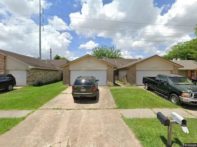 single story home featuring a garage and a front lawn