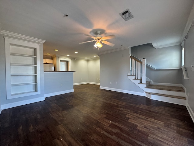 unfurnished living room featuring crown molding, built in shelves, dark wood-type flooring, and ceiling fan