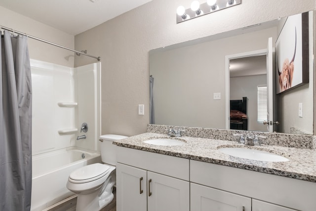 full bathroom with vanity, shower / bath combo, and toilet