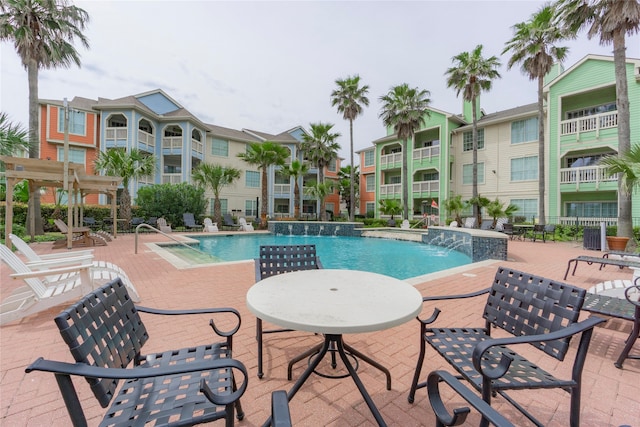 view of swimming pool featuring pool water feature and a patio