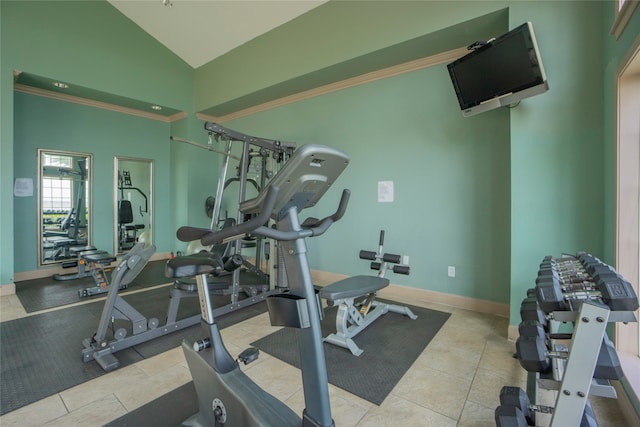 workout room with high vaulted ceiling and light tile patterned flooring