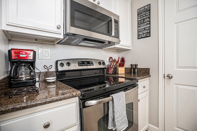 7000 Seawall Blvd Unit 1036, Galveston, TX 77551 - kitchen featuring white cabinets, stainless steel appliances, a textured wall, and dark stone countertops
