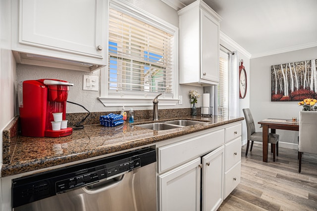 kitchen featuring white cabinets, sink, light hardwood / wood-style flooring, stainless steel dishwasher, and ornamental molding