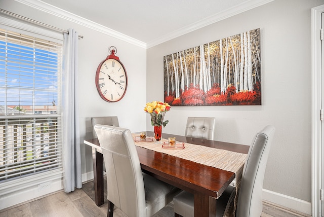 dining room with crown molding and light wood-type flooring