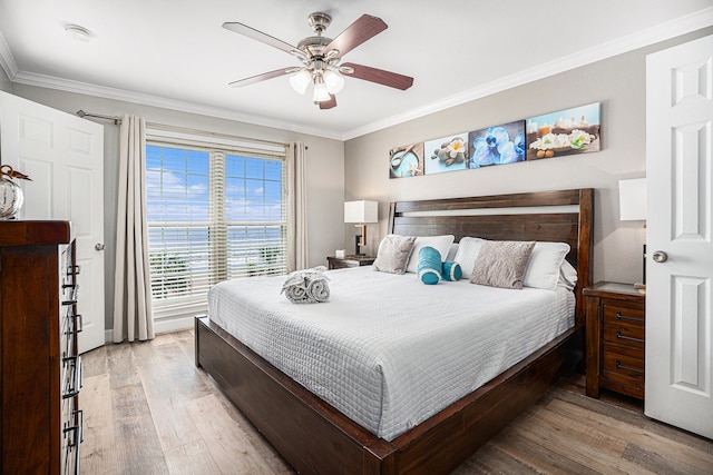 bedroom with light wood-type flooring, ceiling fan, and crown molding