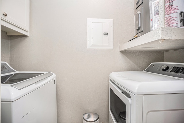 laundry area featuring cabinets, washing machine and dryer, and electric panel