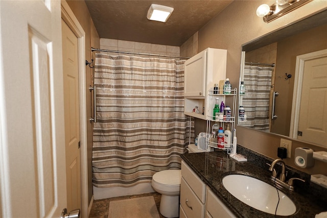 bathroom with a textured ceiling, vanity, and toilet