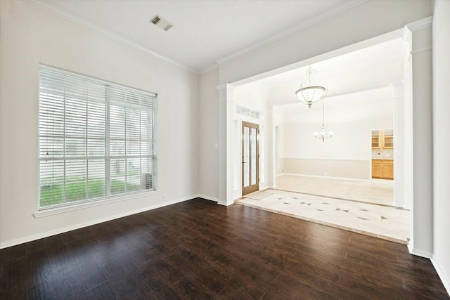 entryway featuring french doors, ornamental molding, a notable chandelier, wood-type flooring, and decorative columns