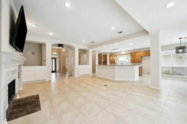 unfurnished living room with a chandelier and light tile patterned floors