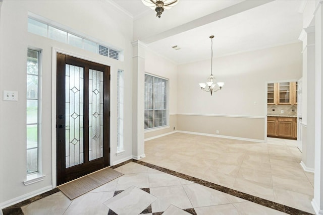 foyer with a chandelier and ornamental molding