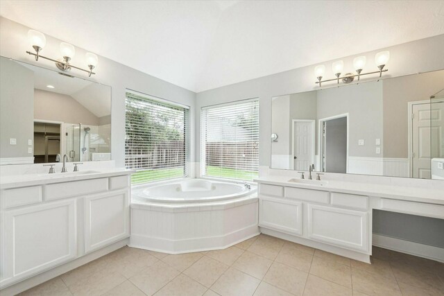 bathroom with tile patterned flooring, vanity, independent shower and bath, and lofted ceiling