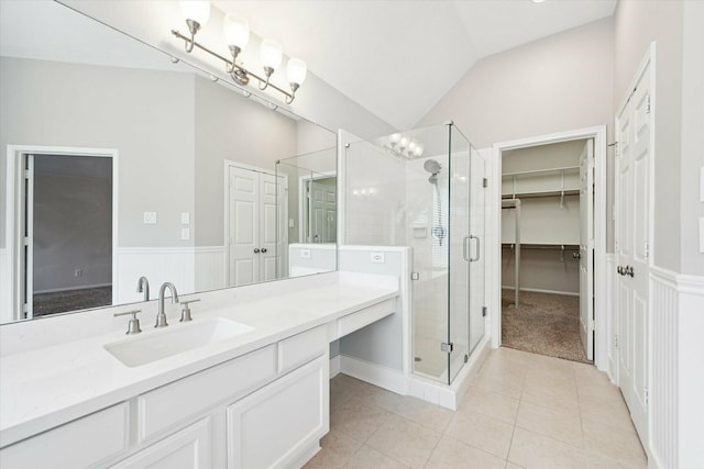 bathroom with tile patterned floors, vanity, a shower with shower door, and lofted ceiling