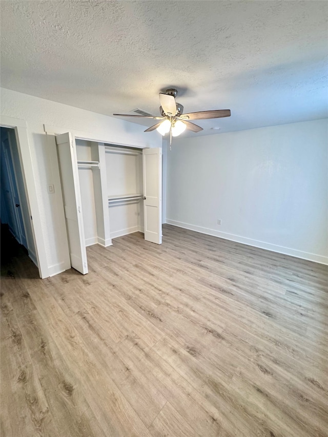 unfurnished bedroom with a textured ceiling, ceiling fan, and light hardwood / wood-style flooring