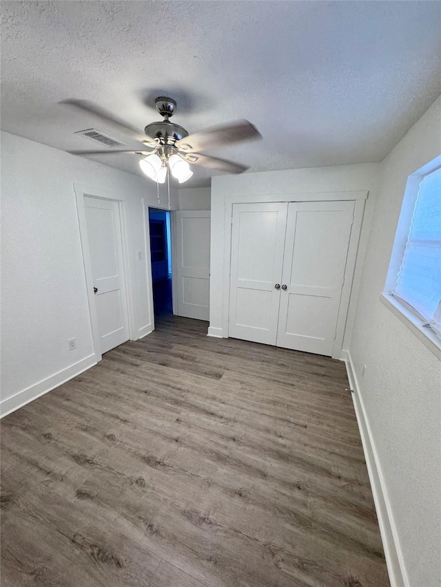 11722 Chadbrook Ln, Houston, TX 77099 - unfurnished bedroom featuring a textured ceiling, baseboards, wood finished floors, a ceiling fan, and a closet