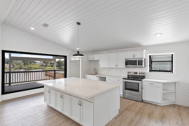 kitchen featuring appliances with stainless steel finishes, white cabinets, pendant lighting, light hardwood / wood-style flooring, and sink