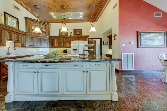 kitchen with sink, crown molding, stone countertops, and decorative light fixtures