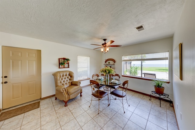 dining room with ceiling fan, a textured ceiling, and light tile patterned flooring