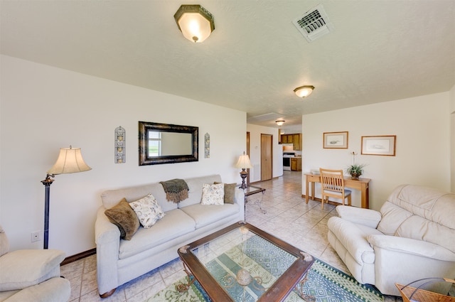 living room with a textured ceiling and light tile patterned floors