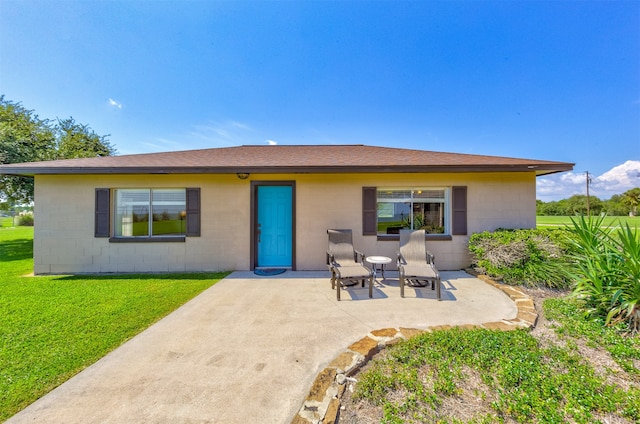 back of property with a patio area and a lawn