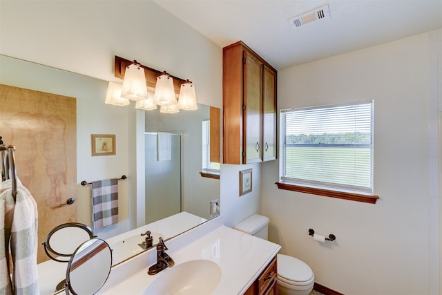 bathroom featuring toilet, vanity, and a shower