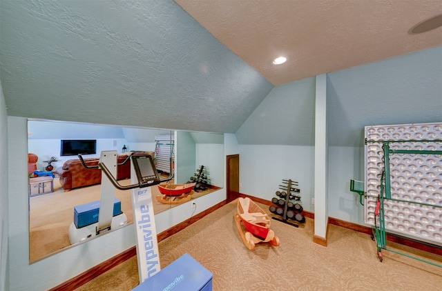 exercise area featuring carpet, vaulted ceiling, and a textured ceiling