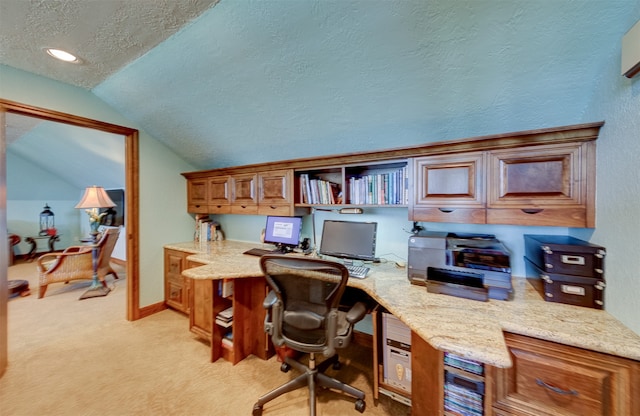 carpeted office with built in desk, a textured ceiling, and vaulted ceiling