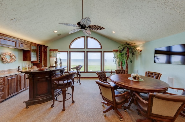 carpeted dining room featuring lofted ceiling, a textured ceiling, and ceiling fan